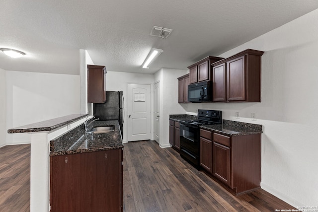 kitchen featuring sink, dark hardwood / wood-style flooring, kitchen peninsula, a textured ceiling, and black appliances