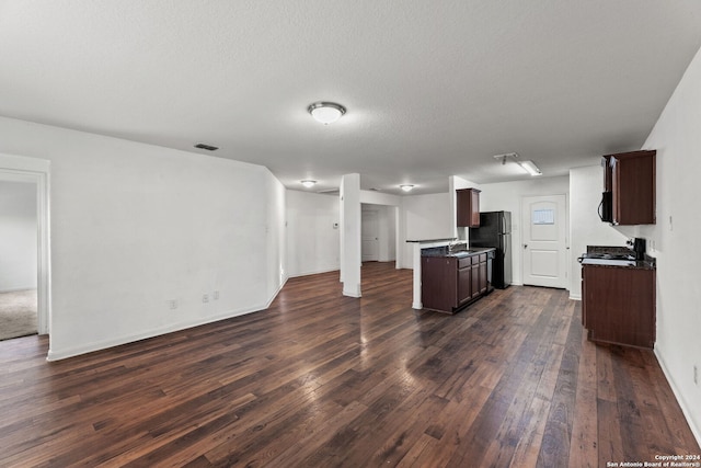 kitchen with a textured ceiling, dark brown cabinetry, dark wood-type flooring, and black appliances