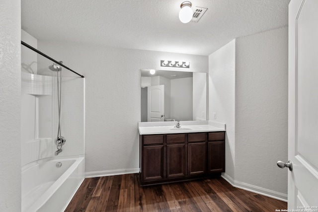 bathroom featuring washtub / shower combination, wood-type flooring, a textured ceiling, and vanity