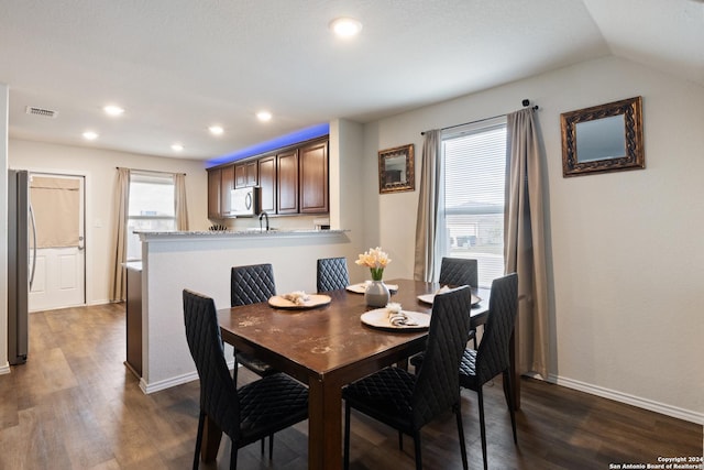 dining area with dark hardwood / wood-style flooring and vaulted ceiling