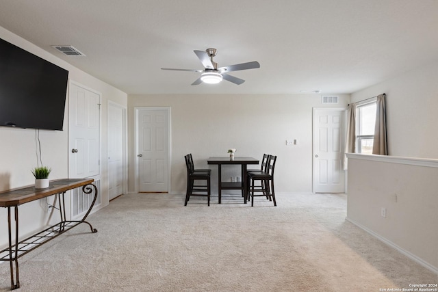 carpeted dining room featuring ceiling fan