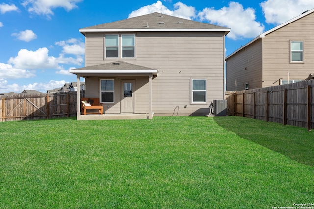 back of house with central AC and a yard