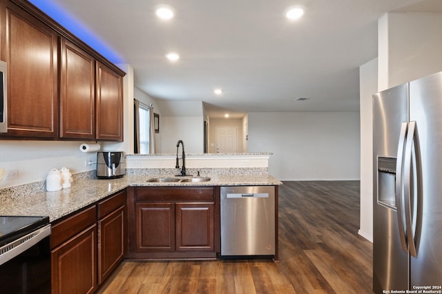 kitchen featuring kitchen peninsula, light stone countertops, stainless steel appliances, sink, and dark hardwood / wood-style floors