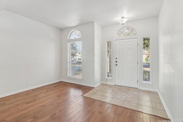 foyer featuring a textured ceiling and light wood-type flooring