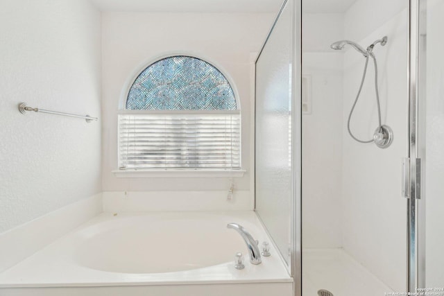 bathroom featuring shower with separate bathtub