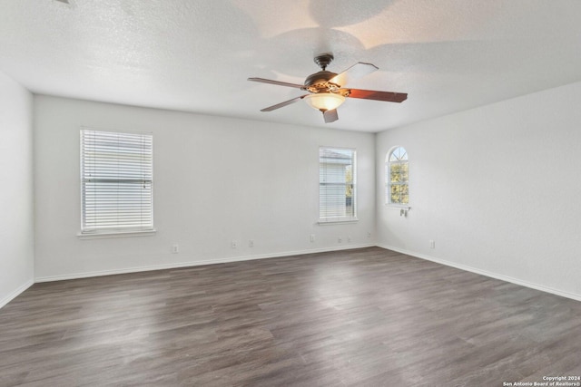 unfurnished room with a textured ceiling, dark hardwood / wood-style floors, and ceiling fan