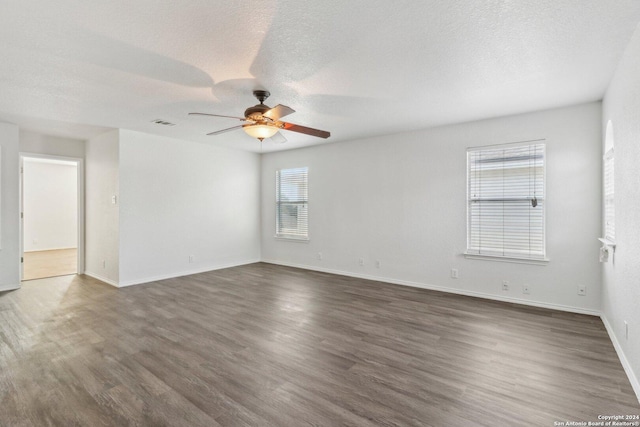 empty room featuring ceiling fan, dark hardwood / wood-style flooring, and a textured ceiling