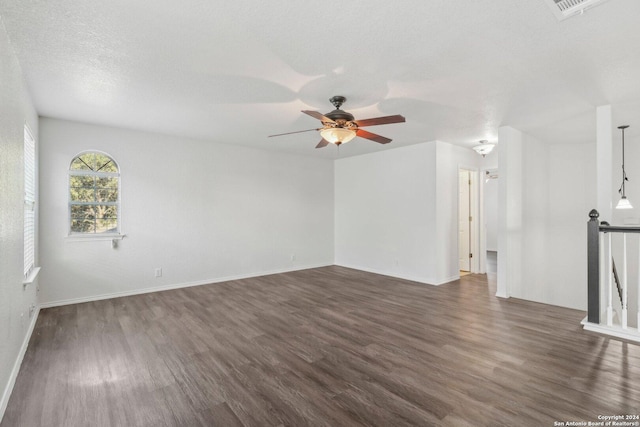 unfurnished living room with dark hardwood / wood-style floors, ceiling fan, and a textured ceiling