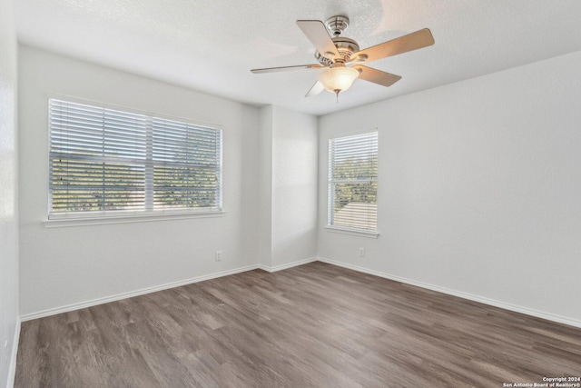 spare room with ceiling fan, dark hardwood / wood-style flooring, and a wealth of natural light