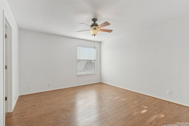 empty room with hardwood / wood-style flooring, ceiling fan, and a textured ceiling