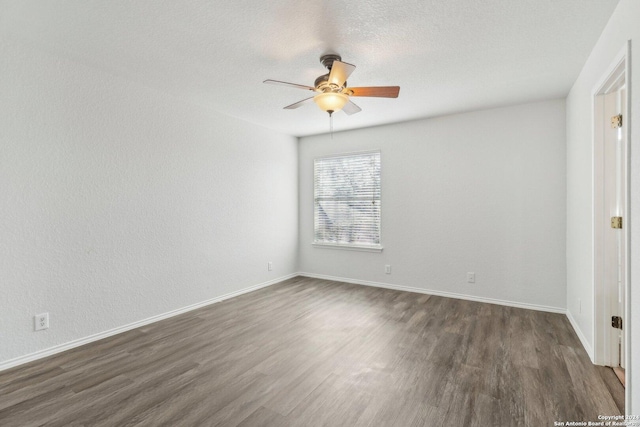 spare room with ceiling fan, dark hardwood / wood-style flooring, and a textured ceiling