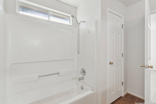 bathroom with shower / tub combination and hardwood / wood-style floors