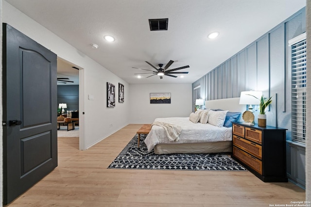 bedroom with ceiling fan, light wood-type flooring, and multiple windows