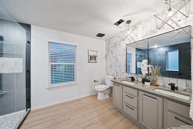 bathroom with vanity, wood-type flooring, tile walls, toilet, and a shower with shower door