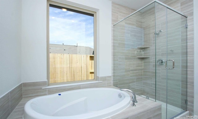 bathroom featuring shower with separate bathtub