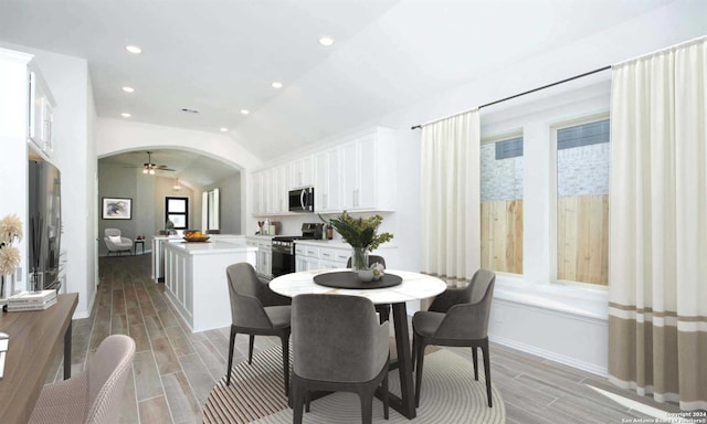 dining room with light hardwood / wood-style flooring, vaulted ceiling, ceiling fan, and a healthy amount of sunlight