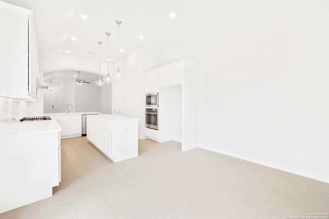 kitchen featuring ceiling fan, a center island, stainless steel appliances, pendant lighting, and white cabinets