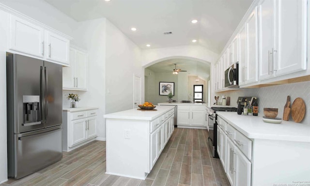 kitchen with appliances with stainless steel finishes, white cabinetry, and a kitchen island