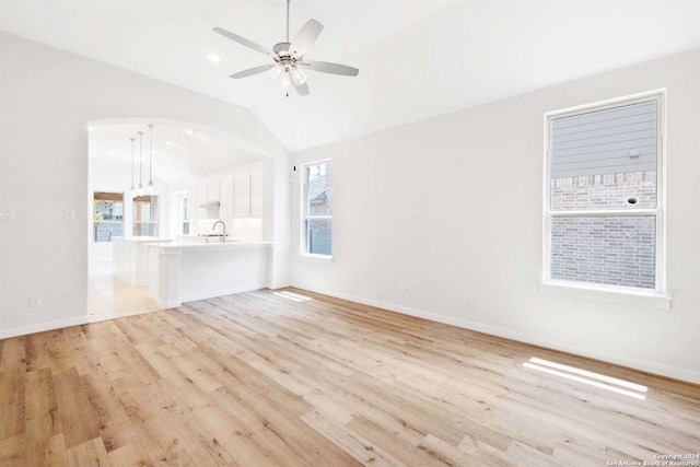 unfurnished living room featuring ceiling fan, sink, and light hardwood / wood-style floors