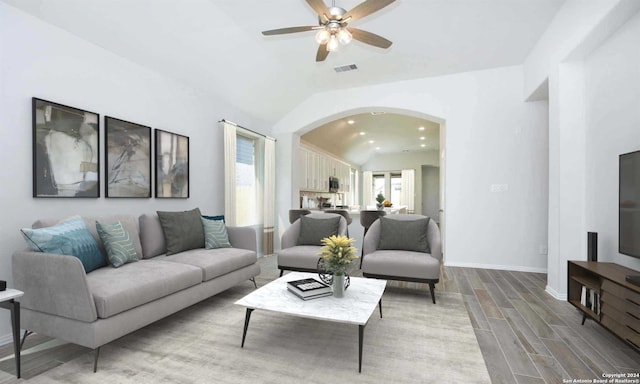 living room with ceiling fan, wood-type flooring, and vaulted ceiling