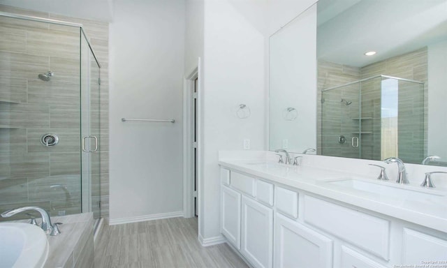 bathroom with wood-type flooring, vanity, and independent shower and bath