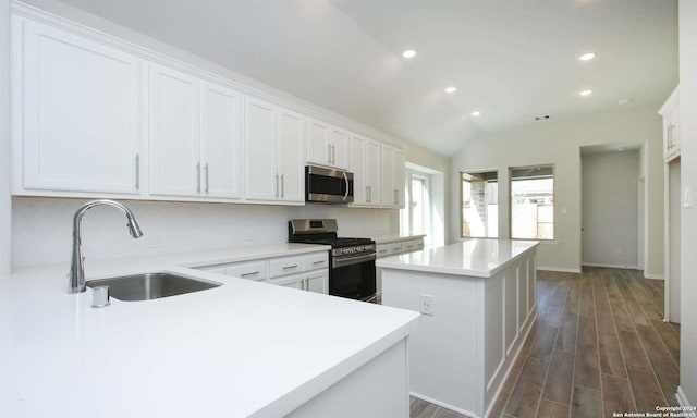 kitchen with white cabinets, a kitchen island, sink, and appliances with stainless steel finishes