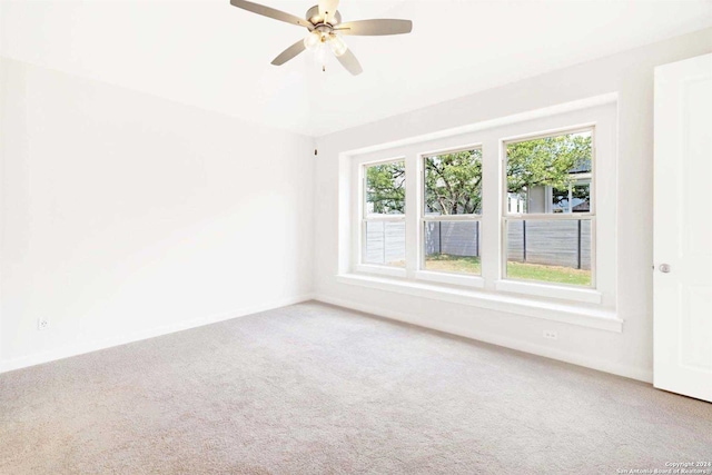 carpeted spare room with ceiling fan