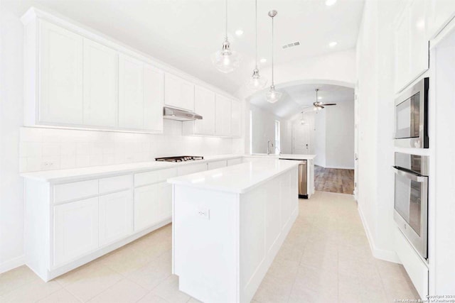 kitchen with ceiling fan, stainless steel oven, and white cabinetry