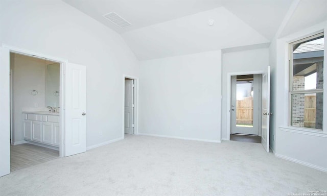 carpeted spare room with sink and vaulted ceiling