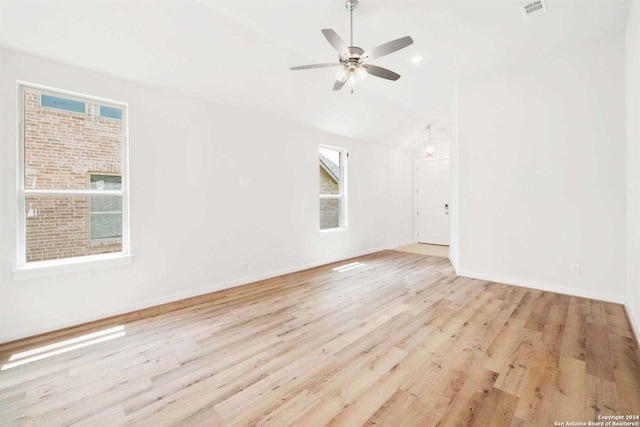 spare room with ceiling fan, light hardwood / wood-style flooring, and vaulted ceiling