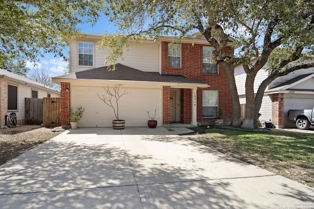 traditional-style house featuring concrete driveway, brick siding, and fence