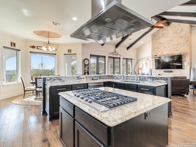 kitchen featuring a center island, light stone counters, island exhaust hood, and an inviting chandelier