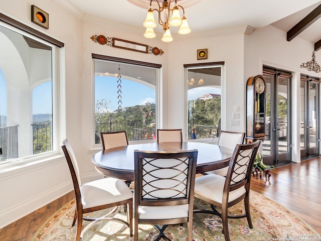 dining area with french doors, a chandelier, and wood-type flooring