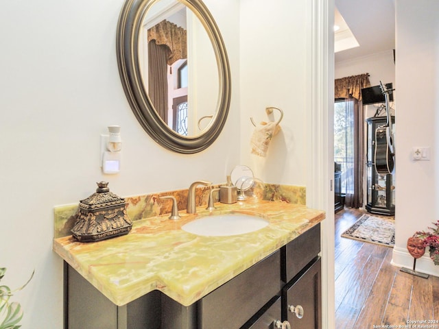 bathroom featuring hardwood / wood-style floors, vanity, and ornamental molding