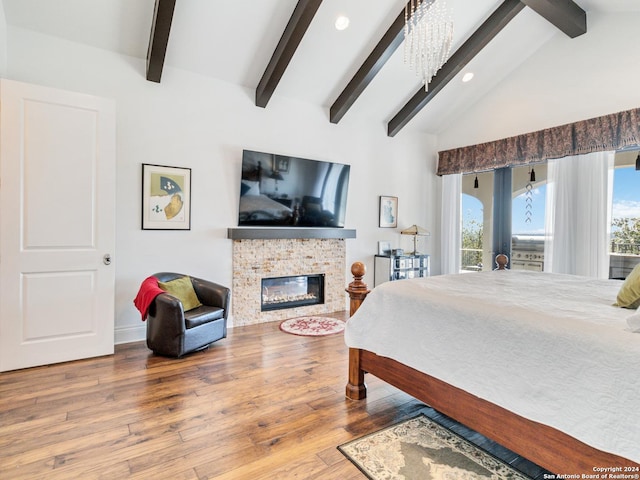 bedroom with multiple windows, a fireplace, and hardwood / wood-style flooring