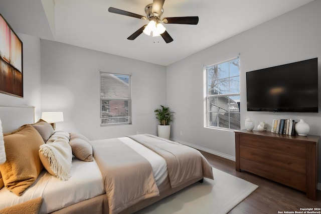 bedroom with ceiling fan and dark hardwood / wood-style floors