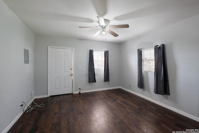 unfurnished room featuring electric panel, ceiling fan, and dark hardwood / wood-style flooring