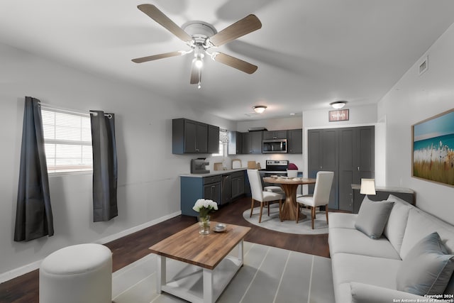 living room with ceiling fan and dark hardwood / wood-style flooring