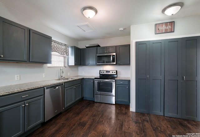 kitchen with gray cabinets, dark hardwood / wood-style flooring, sink, and appliances with stainless steel finishes