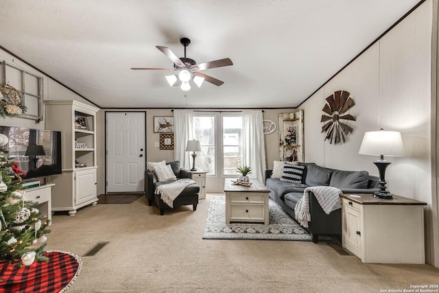 carpeted living room with ceiling fan and crown molding