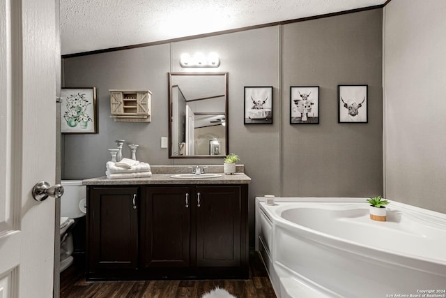 bathroom featuring a washtub, wood-type flooring, vaulted ceiling, a textured ceiling, and vanity