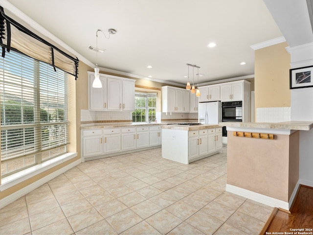 kitchen featuring decorative backsplash, white cabinets, hanging light fixtures, and ornamental molding