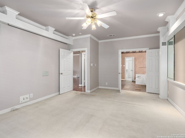 unfurnished bedroom with ceiling fan, light colored carpet, ornamental molding, and ensuite bath