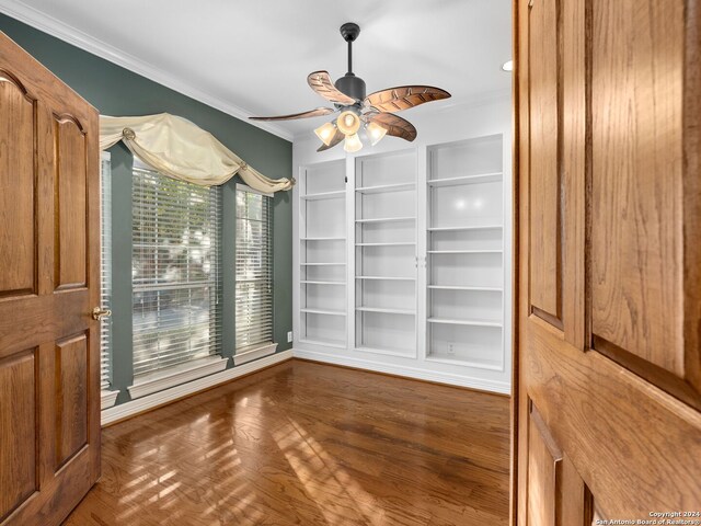 unfurnished dining area featuring ceiling fan, crown molding, and dark hardwood / wood-style floors