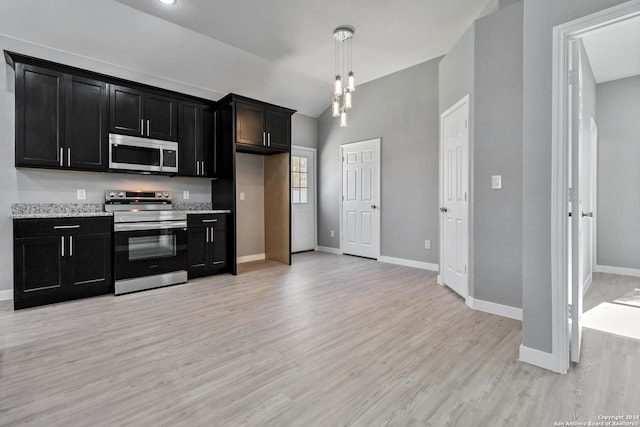 kitchen featuring pendant lighting, light stone countertops, light hardwood / wood-style flooring, and stainless steel appliances