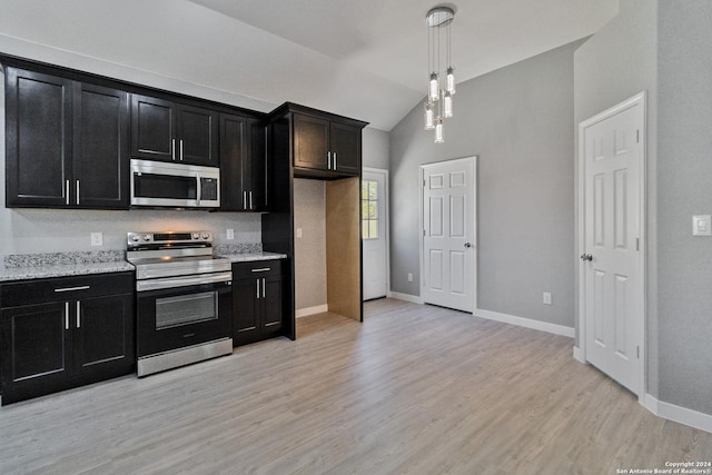 kitchen featuring high vaulted ceiling, light hardwood / wood-style flooring, decorative light fixtures, light stone counters, and stainless steel appliances