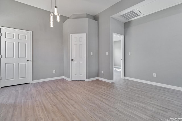 unfurnished bedroom with a towering ceiling and light hardwood / wood-style floors