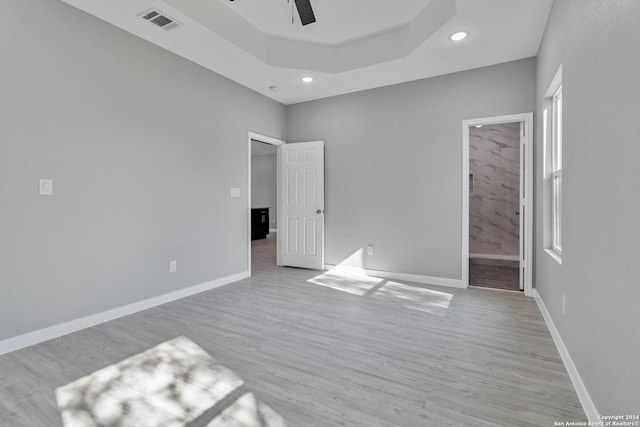 unfurnished bedroom featuring ensuite bathroom, ceiling fan, and light hardwood / wood-style flooring