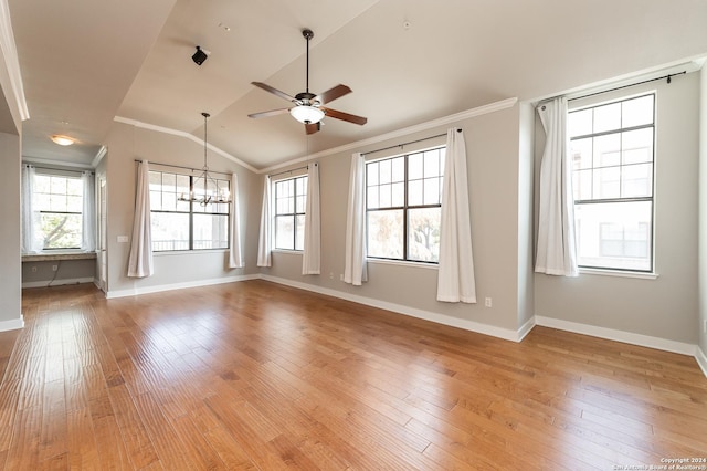 unfurnished room featuring ceiling fan with notable chandelier, light hardwood / wood-style floors, ornamental molding, and vaulted ceiling