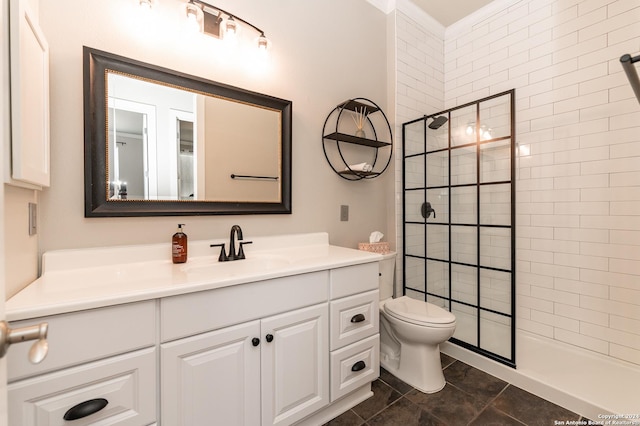 bathroom with toilet, a tile shower, vanity, and tile patterned floors